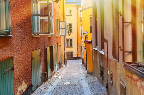 The narrow cobblestone street with a bicycle and medieval houses of Gamla Stan historic old center of Stockholm at summer sunny day.