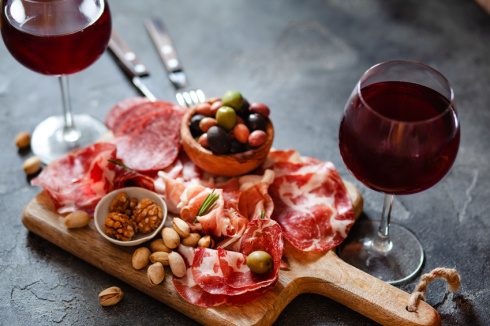 Meat plate, cold smoked pork, jamon, prosciutto, salami served with wine, nuts and olives